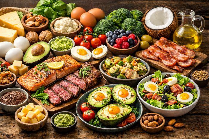 Healthy keto diet food spread with salmon, steak, avocado, eggs, and bacon.